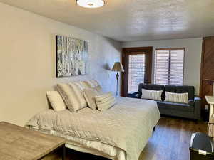 Bedroom featuring dark wood-style flooring and a textured ceiling