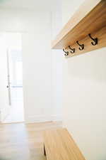 Mudroom featuring light wood-style floors and baseboards