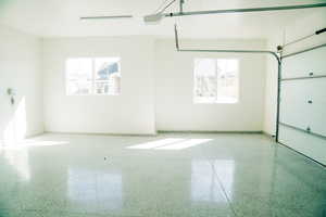 Garage with baseboards and a garage door opener