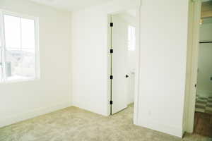 Unfurnished bedroom with carpet flooring and baseboards