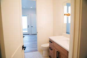 Half bath with vanity, toilet, and recessed lighting