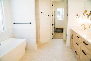 Bathroom with vanity, a soaking tub, and tiled shower