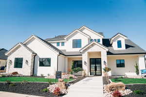 View of front of property with stone siding, a tiled roof, and stucco siding