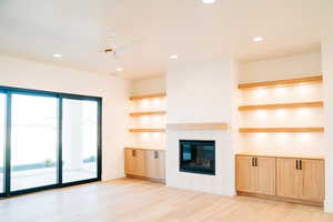 Unfurnished living room featuring recessed lighting, light wood-type flooring, a tile fireplace, and a ceiling fan