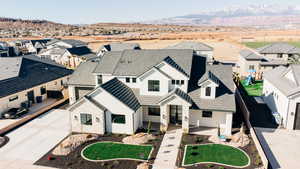 View of front of property with a residential view, a mountain view, and driveway