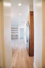 Hall featuring light wood finished floors and recessed lighting