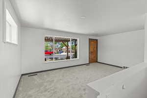 Carpeted empty room featuring baseboards