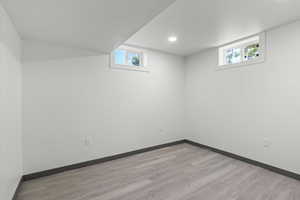 Below grade area featuring light wood-style floors, baseboards, and recessed lighting