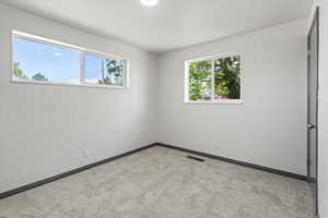 Unfurnished bedroom with carpet flooring and baseboards