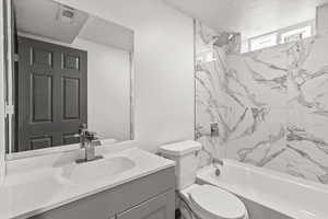 Bathroom featuring vanity, shower / bathtub combination, and toilet