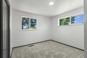 Carpeted empty room featuring baseboards