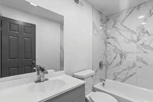 Full bath with vanity, shower / bath combination, and toilet