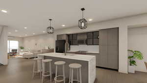 Kitchen with a sink, modern cabinets, light countertops, a kitchen bar, and light wood-style flooring