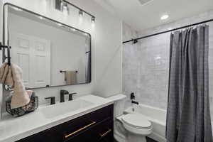 Bathroom featuring toilet, vanity, and shower / tub combo with curtain