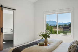 Bedroom featuring a mountain view, a barn door, and baseboards