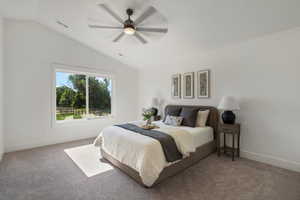Carpeted bedroom featuring lofted ceiling, baseboards, and ceiling fan
