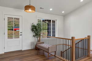Entryway with wood finished floors, baseboards, and recessed lighting