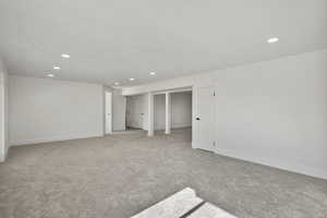 Unfurnished room with recessed lighting, light colored carpet, and baseboards