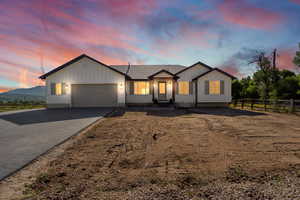 View of front of property featuring a garage, driveway, and board and batten siding