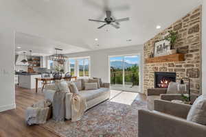 Living area featuring wood finished floors, a fireplace, lofted ceiling, a ceiling fan, and recessed lighting