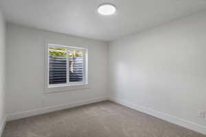 Spare room featuring carpet and baseboards