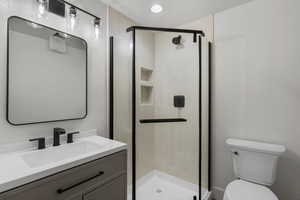 Full bath featuring toilet, vanity, and a stall shower
