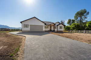View of front of house featuring an attached garage, decorative driveway, board and batten siding, and a mountain view