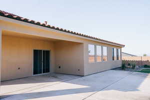 Back of house with a patio area, a tile roof, and stucco siding