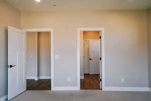 Unfurnished bedroom featuring baseboards and carpet