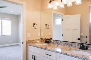 Full bath with double vanity and baseboards