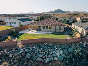 Back of property featuring a mountain view, a patio, a gate, and a tile roof