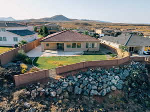 Back of property featuring a patio, a mountain view, a tile roof, and a residential view