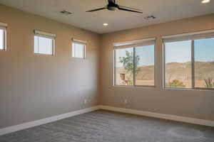 Carpeted spare room featuring baseboards, plenty of natural light, ceiling fan, recessed lighting, and a mountain view