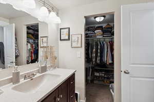 Bathroom with vanity and a spacious closet
