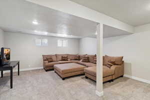 Living area with a textured ceiling, light carpet, baseboards, and recessed lighting