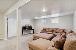 Living room with light colored carpet, baseboards, and recessed lighting