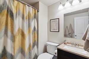 Bathroom featuring vanity, toilet, and a shower with curtain