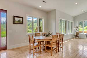 Dining area with light wood-type flooring, baseboards, recessed lighting, and vaulted ceiling