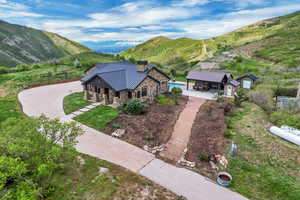 Aerial view of property and surrounding area featuring a mountainous background