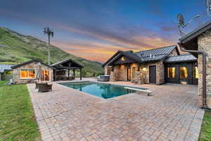 Outdoor pool with a patio area, a mountain view, outdoor lounge area, a gazebo, and an outbuilding