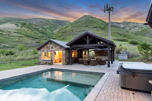 Outdoor pool with an outdoor living space, a hot tub, an outdoor structure, and a patio