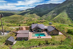 View from above of property with a pool area and a mountainous background