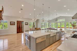 Kitchen with a warming drawer, gray cabinetry, a sink, a chandelier, and appliances with stainless steel finishes