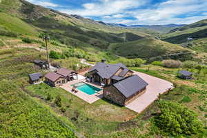 Aerial view of property and surrounding area featuring a pool area and a mountain backdrop