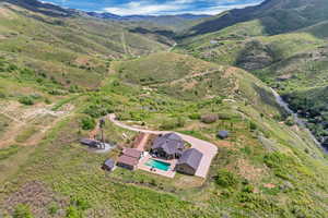 Aerial view of property and surrounding area featuring a mountain backdrop and a pool area