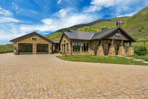 View of front of house featuring a standing seam roof, stone siding, and a mountain view