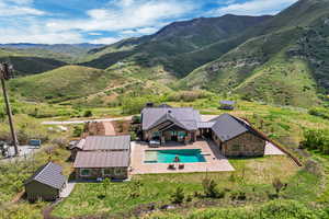 View from above of property with a pool area and a mountain backdrop