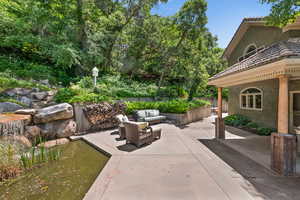 View of patio / terrace, waterfall and pond