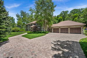 Front view, 3 car garage and stone driveway.