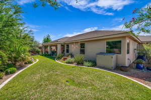 Rear view of property featuring stucco siding, a lawn, and a tiled roof